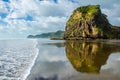 Piha Beach view with reflection in the sea with blue sky with white clouds above, Northland, North Island, New Zealand Royalty Free Stock Photo