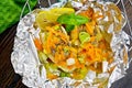 Pike with carrots and basil in foil on board top