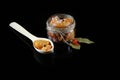 Pike caviar, roe in a glass jar, red hot pepper, laurel leaves, wooden spoon of fish caviar on a black background, top view, set Royalty Free Stock Photo