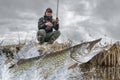 Pike fishing. Fisherman catch big muskie fish splashing in water