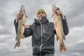 Pike fishing. Happy fisherman with big fish trophy at the boat with tackles Royalty Free Stock Photo