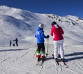 Female skier with a jacket written ITA which is short for Italy and pants with the italian flag at resort in sunny winter day