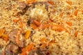 Pilaf close-up. Oriental cuisine concept. National Uzbek pilaf with meat in a cast-iron pan. Top view, lamb, devzira