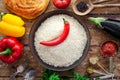 Pilaf ingredients, rice, vegetables, pita, cutlery, spices on rustic background Royalty Free Stock Photo