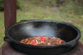 Pilaf prepare in big black cast iron with chefs hand.