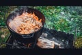 Pilaf prepare in a cauldron on a fire.