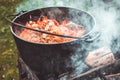 Pilaf prepare in a cauldron on a fire.