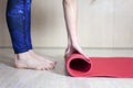 Pilates background. Unrecognizable woman rolling up yoga mat after training. Sport class before or after practicing yoga,