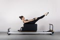 pilates machine, woman in sportswear exercising in the gym