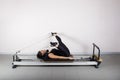 pilates machine, mixed race womanexercising in the gym