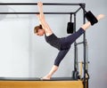 Pilates woman in cadillac split legs stretch exercise