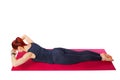 Pilates or yoga. A slender athletic girl performs the chest extension exercise lying on her stomach.