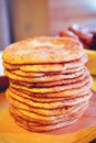 Pile of air pancakes on a wooden dinette, a traditional food family. pancakes of golden color Royalty Free Stock Photo