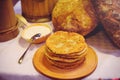 Pile of air pancakes on a wooden dinette, a traditional food family. pancakes of golden color, sour cream in the background Royalty Free Stock Photo