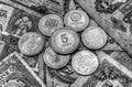 A pile of anniversary coins over a background of banknotes in black and white