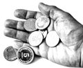 A pile of anniversary coins of republic of Bulgaria in a human`s hand in black and white