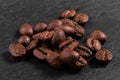 Pile of arabica coffee beans on a dark black background close-up