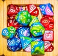 Pile of assorted gaming dice in wooden bowl - top down view