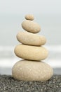 Pile of balanced rocks on black sandy beach