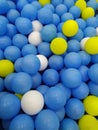 Pile of balls . Blue ball . White ball . Yellow ball . Kids play zone . Ball background . Fun background