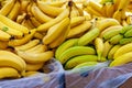 Pile of banana bunches in cardboard boxes for sale in grocery store