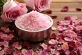 pile of bath salts with dried rose petals on wooden surface Royalty Free Stock Photo