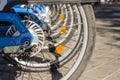 A pile of bicycle wheels parked at an electric charging station on a central street in a European city