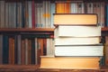Pile of big books with blurry bookshelf in the background and copy space. Knowledge, reading, study, literacy or literature Royalty Free Stock Photo