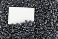 Pile black beans and note paper. Royalty Free Stock Photo