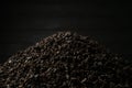 A pile of black fanning or broken loose leaf tea on a dark black background. Close-up, side view. Royalty Free Stock Photo