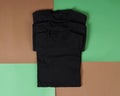 Top view of folded black t-shirt isolated with colored background  copy space  flat lay. Royalty Free Stock Photo