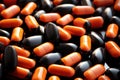 A pile of black and orange pills, suitable for medicinal purposes., Pile of orange-black capsule pills, AI Generated Royalty Free Stock Photo