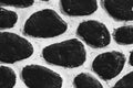 Pile of black painted stones textured pattern on a white wall for background Royalty Free Stock Photo