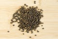 Pile of Black peppercorns Black pepper dried seeds on bamboo wooden background Royalty Free Stock Photo