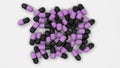 Pile of black and purple medicine capsules