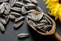 Pile of black roasted salty sunflower seeds with flower on rustic table