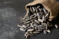 Pile of black roasted salty sunflower seeds with flower on rustic table