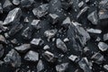 A pile of black rocks sits on a dark, smooth surface Royalty Free Stock Photo