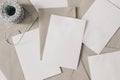 Pile of blank letters with craft envelopes and decorative rope on table. Closeup of empty greeting cards, invitations