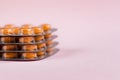 Pile of blisters with medicine pills on pink background. Stack of tablets, capsules Royalty Free Stock Photo