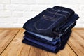 Pile of blue jeans on wooden floor Royalty Free Stock Photo