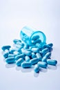 Pile of blue pills spilling out of blue bottle. Generative AI Royalty Free Stock Photo