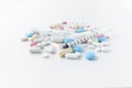 Pile of blue, white, pink and yellow colored pills and capsules with medical syringe Royalty Free Stock Photo