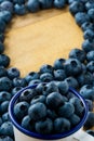 Pile of blueberries in cup and on table, fruit background with text space Royalty Free Stock Photo