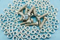 Pile of bolts and nuts on a blue background. Background with nuts and bolts. Royalty Free Stock Photo