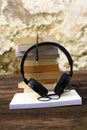 A pile of books audio headset on a wooden table Royalty Free Stock Photo