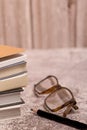 pile of books with a pair of glasses and a black pencil Royalty Free Stock Photo