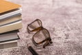 pile of books with a pair of glasses and a black pencil Royalty Free Stock Photo