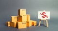 Pile of boxes and easel with dollar red arrow down graph chart. Drop in profits, slowdown in sales. Fall in imports or exports, Royalty Free Stock Photo