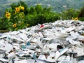 pile of broken china ready to be recycled and used as raw material for construction bricks with a garden of sunflowers